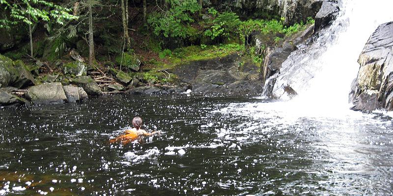 Swimming at the foot of a waterfall